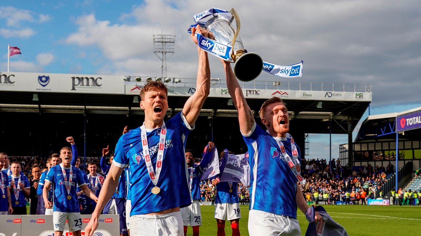 Sean Raggett and Jack Sparkes lift the League One trophy at Fratton Park