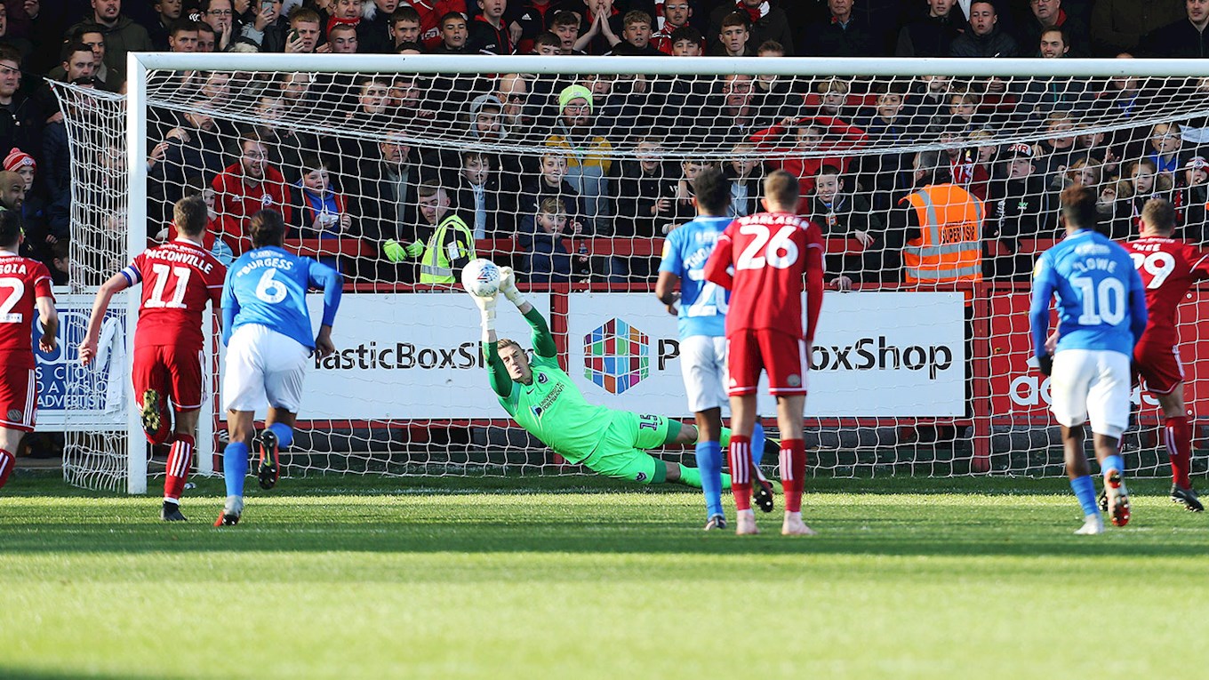 Craig MacGillivray saves a penalty for Pompey at Accrington Stanley